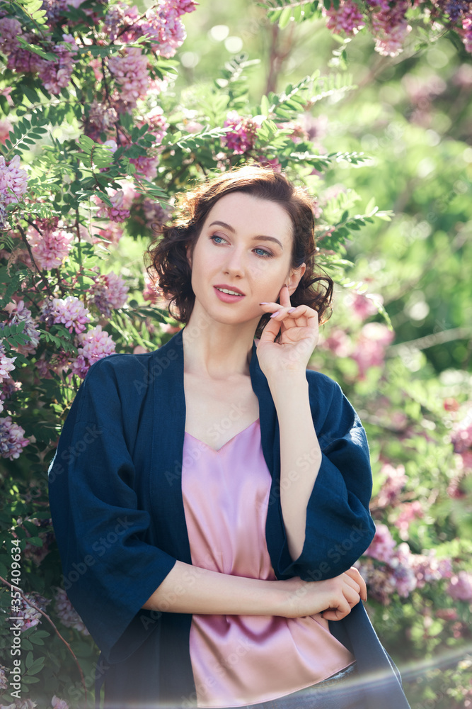Young beautiful dreamy girl on a background of blooming acacia. Outdoor portrait of romantic woman. Young beautiful dreamy girl on a background of blooming acacia. Outdoor portrait of romantic woman.