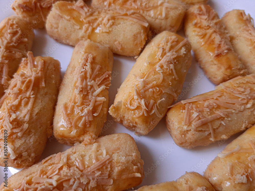 Kaasstengels or Kastengel or Kue Keju, is Dutch influenced-Indonesian cheese cookie in the form of sticks. Isolated in white background Kaasstengels or Kastengel or Kue Keju, is Dutch influenced-Indonesian cheese cookie in the form of sticks. Isolated in white background