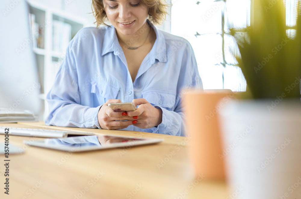 Happy woman working using multiple devices on a desk at home Happy woman working using multiple devices on a desk at home
