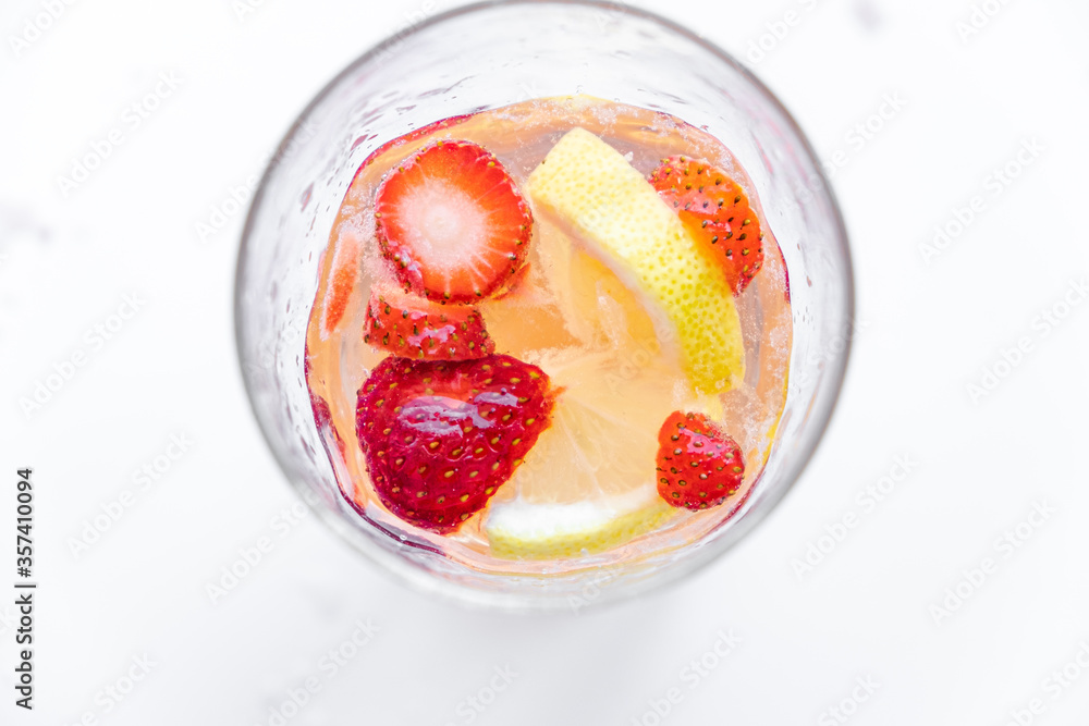 A refreshing summer drink made from soda and fruit. strawberries, lemon, apple. fruit in a glass, flying spray. healthy eating. quenching thirst A refreshing summer drink made from soda and fruit. strawberries, lemon, apple. fruit in a glass, flying spray. healthy eating. quenching thirst