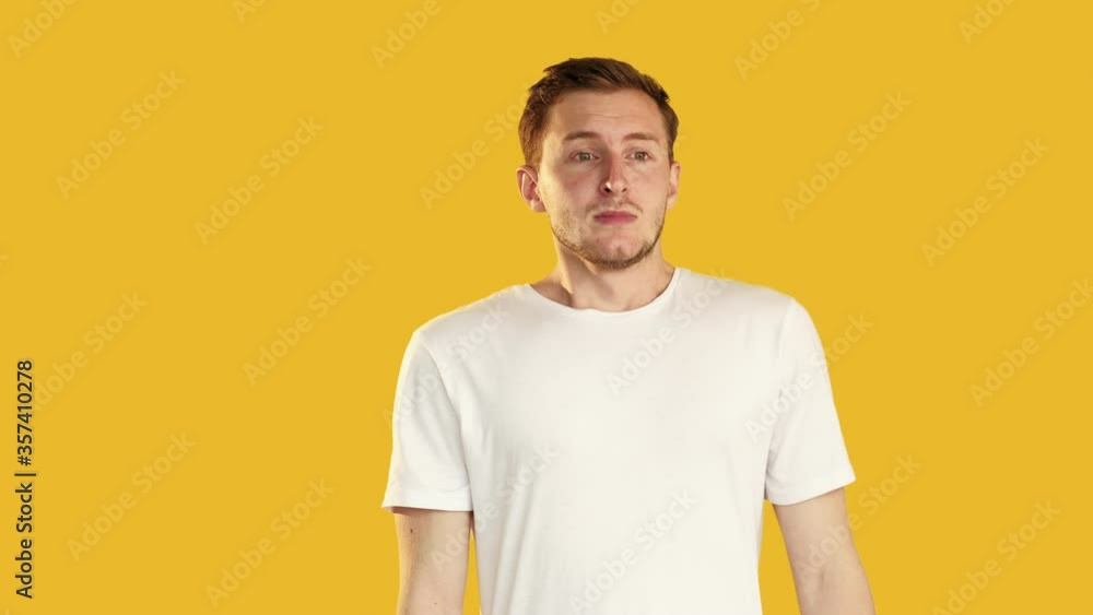 Sad guy portrait. Despair disappointment. Depressed man in white t-shirt crying isolated on orange background. Sad guy portrait. Despair disappointment. Depressed man in white t-shirt crying isolated on orange background.