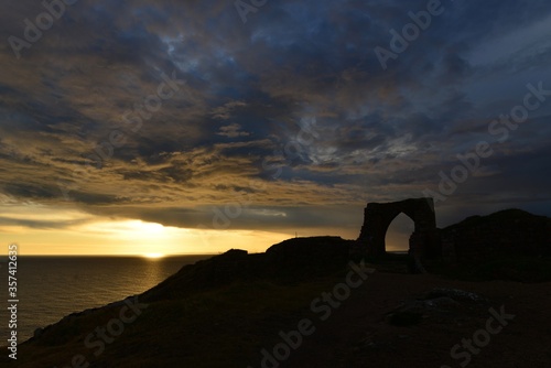 Gronez Castle, Jersey, U.K. 1330 ruin with a Summer dramatic stormy sunset.