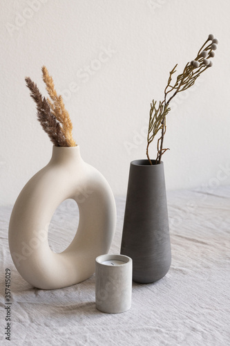 Foto Two ceramic handmade vases with dried wildflowers and spikes and aromatic candle