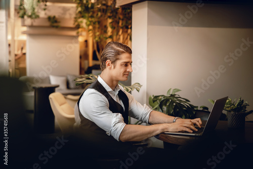 Smiling Businessman Working on Computer Laptop in Creative Working Space or Cafe