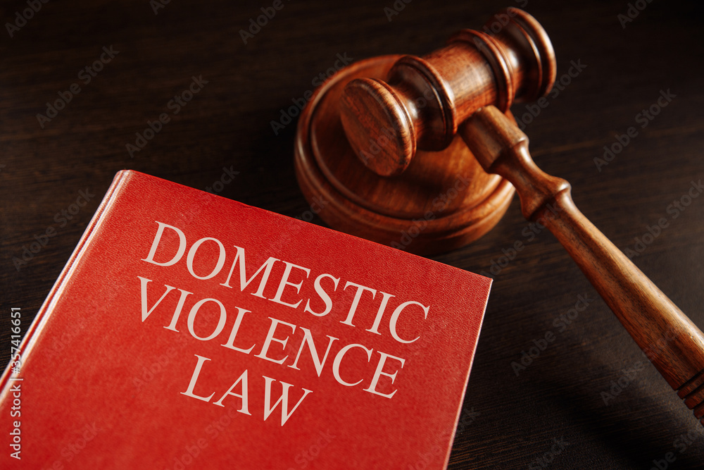 Domestic violence concept. Wooden gavel on the big red book. Juridical protection