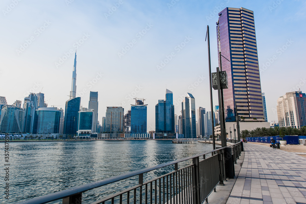 Dubai water canal boardwalk with skyscrapers on the background.