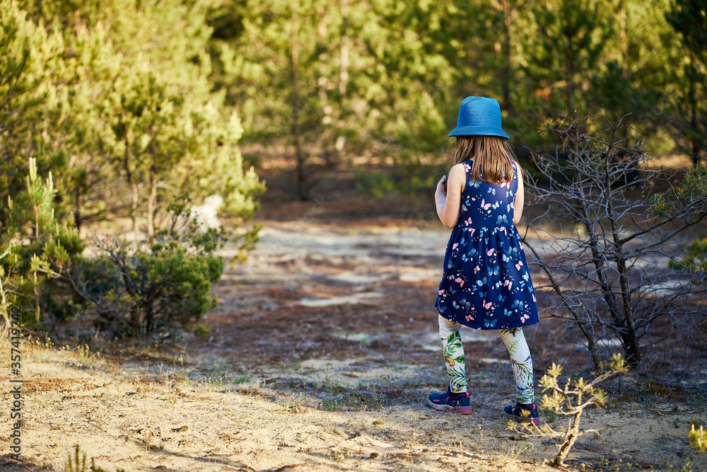 girl in a summer dress runs in a pine forest girl in a summer dress runs in a pine forest