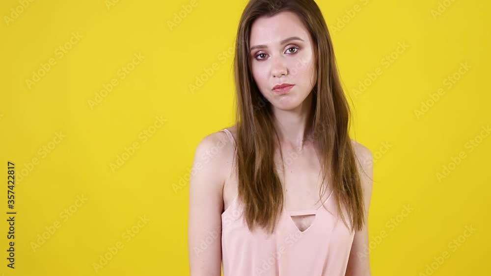 Young negative bored woman make blah blah gesture with hand isolated over yellow background. People emotions lifestyle concept. Young negative bored woman make blah blah gesture with hand isolated over yellow background. People emotions lifestyle concept.