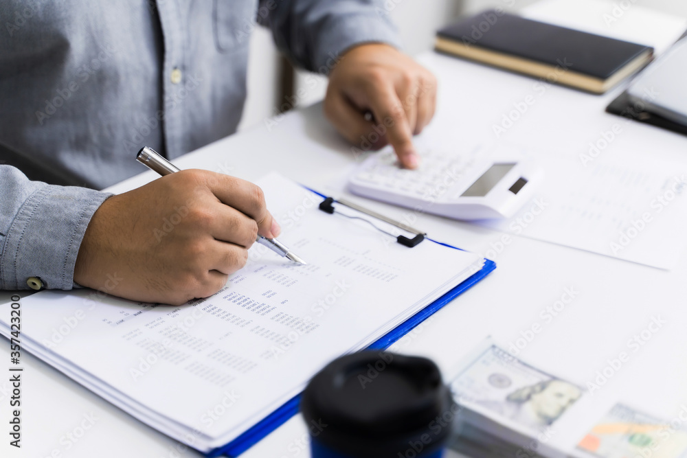 Accountant calculating valuation of financial data paperwork. Accountant calculating valuation of financial data paperwork.