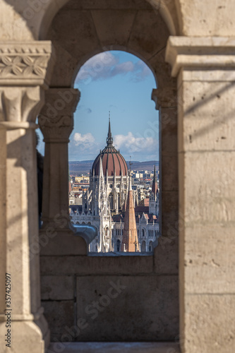 Red dome of Hungarian Parliament throuh corridor view on Fisherman's Bastion on Buda hill in Budapest photo