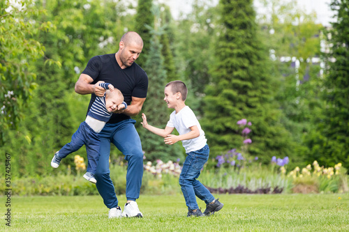 Father plays with little boy son, hug baby in the park on a warm summer day. Happy childhood concept. Happiness and harmony of family life. Great family vacation.