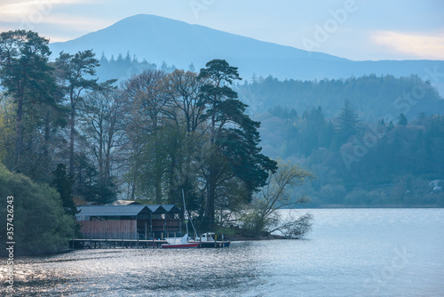 A boathouse by a lake with mountains in the background at the Lake District National Park, Cumbria, England. photo