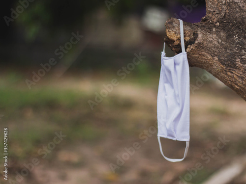 Fabric mask Hanging on a branch can be washed and dried in the shade for reuse. Prevent infection from COVID-19 epidemic.White cotton sanitary face mask. cloth mask.
