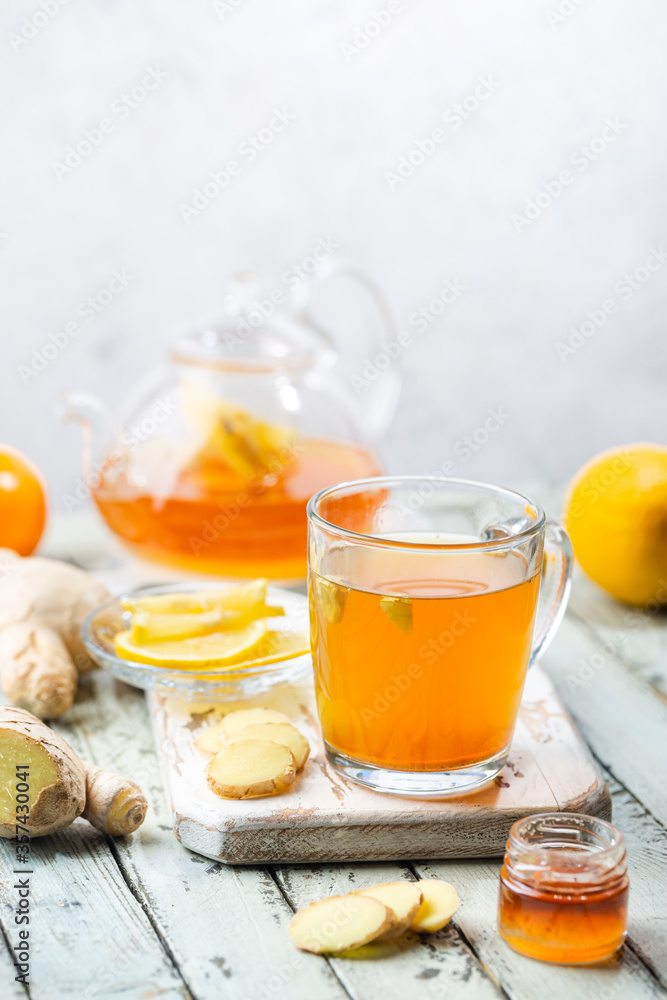 Ginger tea in a glass cup with lemon and mint on light background Ginger tea in a glass cup with lemon and mint on light background