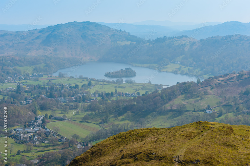 Grasmere village and lake and Loughrigg Fell in the background, seen from the summit of Helm Crag, Grasmere, Lake District National Park, Cumbria, UK.