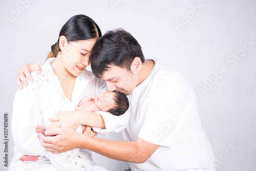 Parents carrying baby. portrait of young family with little son. selective focus of of happy young father kiss mother and hugging infant baby.