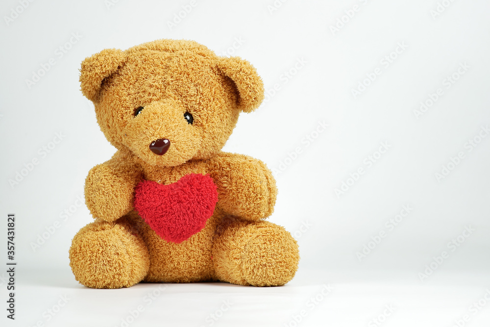 Teddy Bear doll sitting and red heart symbol for lover. Isolated on white background