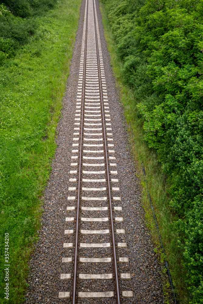 some Railway tracks on a railway track bed lead through the picture some Railway tracks on a railway track bed lead through the picture