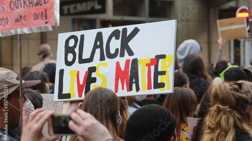 Sydney, NSW / Australia - June 6 2020: Black Lives Matter Protest March. Protesting Aboriginal deaths in custody and the death of. Sign reading 'black lives matter' in aboriginal colors