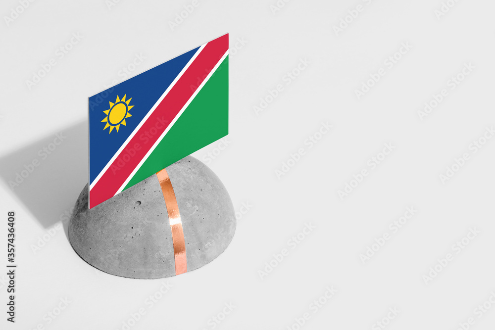 Naklejka premium Namibia flag tagged on rounded stone. White isolated background. Side view minimal national concept.