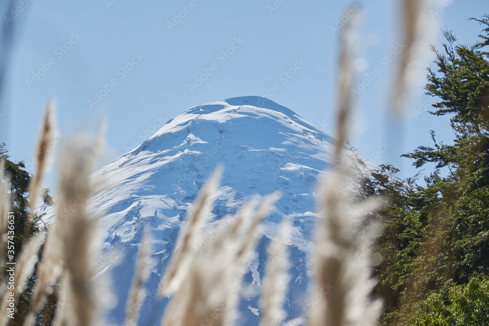Obraz premium PETROHUE, CHILE - FEBRUARY 11, 2020: The waterfalls, rapids and tourists of Petrohue on a sunny day in the lake region of Chile, near of Puerto Varas. Osorno volcano.