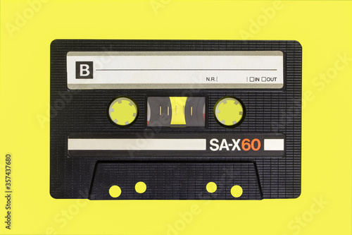 Vintage cassette tape isolated. Black audio cassette B side on yellow background. photo