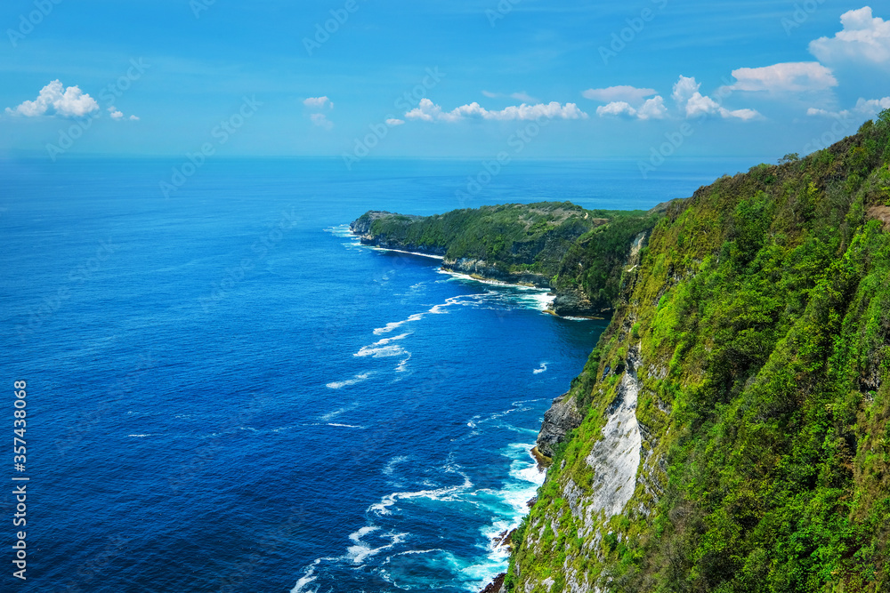A view of a cliff and blue sea in Bali, Indonesia.
