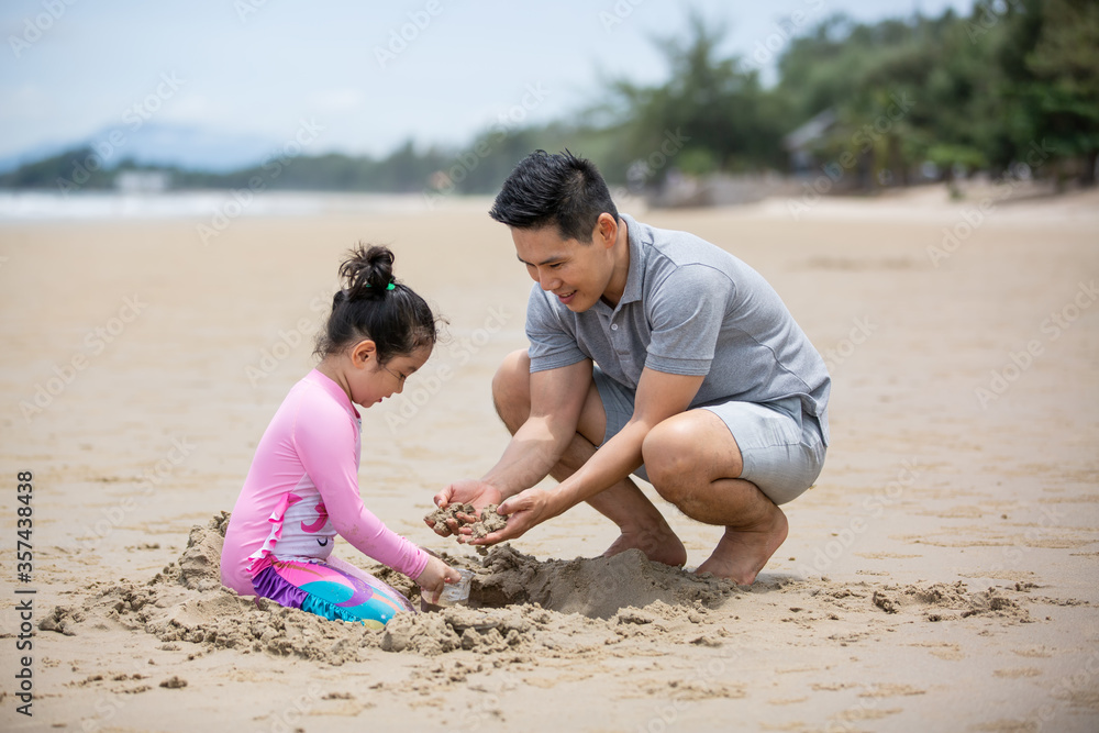 Girl and dad playing sand on the beach Girl and dad playing sand on the beach