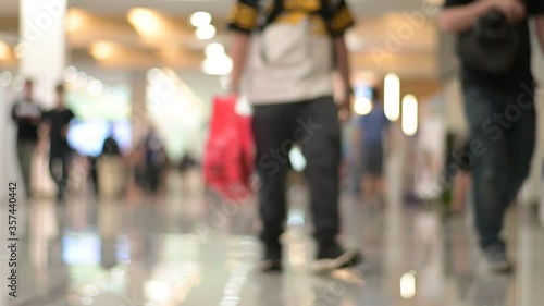 Blurred people walk at hallway shopping in hall exhibition trade fair with wearing mask