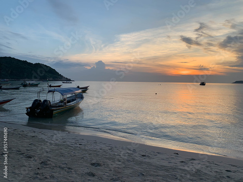 Sunrise and docked boats at Perhentian Island beach Malaysia