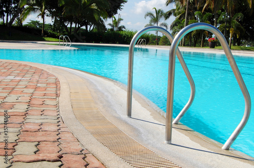Outdoor swimming pool with surrounding tall trees 