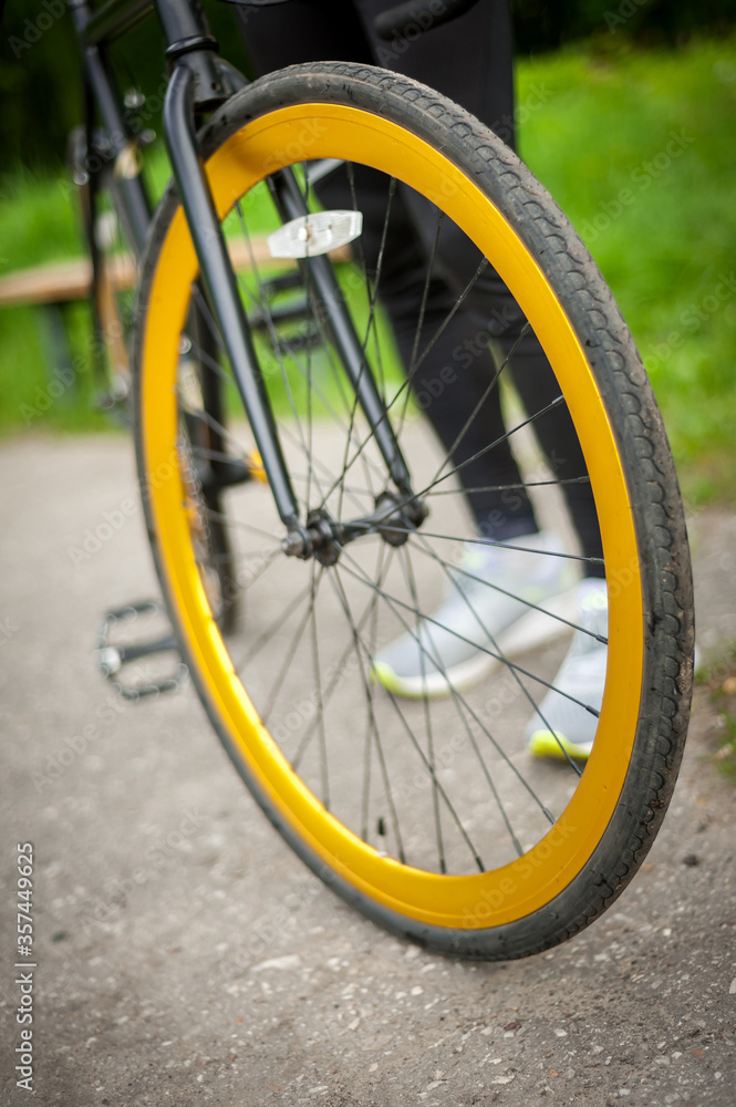 Cyclist with his bike, close up. Outdoor photography. you can see his hands and the wheel.