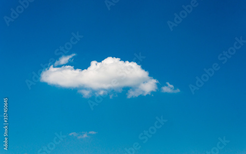 a white fluffy light cloud in the blue summer sky. Transparent blue sky and snow-white cloud.