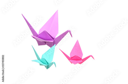 three colorful origami cranes flying on white
