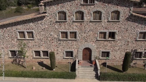 Aerial drone masia Cavall Bernat house above traveling mountain front door window stone ancient old garden photo
