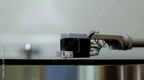 Close up of a vintage turntable needle playing a LP vinyl disc in slow motion
