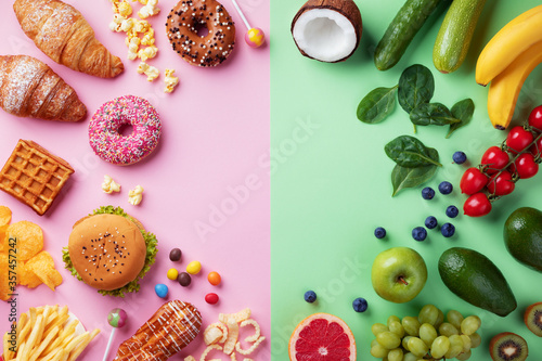 Healthy and unhealthy food background from fruits and vegetables vs fast food, sweets and pastry top view. Diet and detox against calorie and overweight lifestyle concept. photo