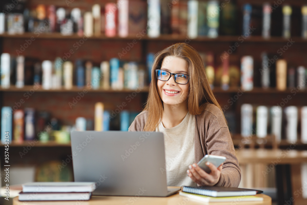 Young smiling girl happy working on laptop in cafe Young smiling girl happy working on laptop in cafe