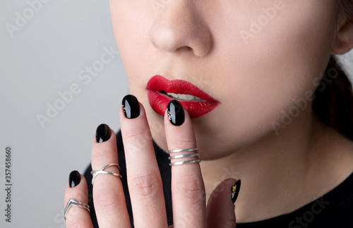 Beautiful young woman with bright makeup and black nail design