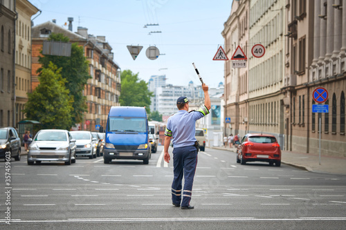 Policeman directing traffic in the city. Traffic police adjusts traffic at the intersection of  avenue, rush hour. Police officer regulating traffic on city streets. DPS - Inscription Road Police photo