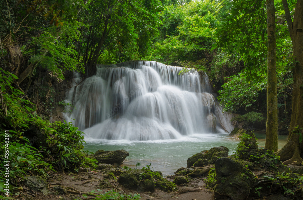 Fototapeta premium Beautiful natural landscape scene of waterfall in rain forest with green trees in long exposure photography