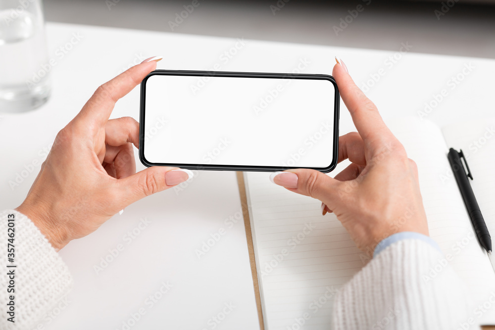 Watch videos and lessons online. Woman hands holds smartphone Watch videos and lessons online. Woman hands holds smartphone