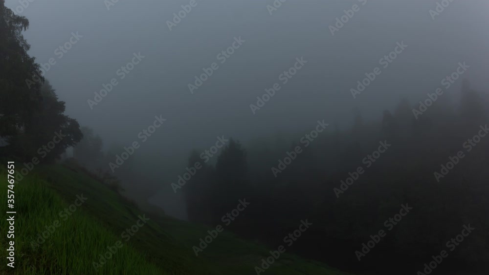 Beautiful dark dramatic landscape with motion of fog over river and green trees of forest. Timelapse 4K of early morning countryside landscape. Beautiful dark dramatic landscape with motion of fog over river and green trees of forest. Timelapse 4K of early morning countryside landscape.