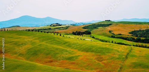 Traditional countryside and landscapes of beautiful Tuscany. Fields in golden colors and cypresses. Holiday  traveling concept. Vintage tone filter effect with noise and grain.