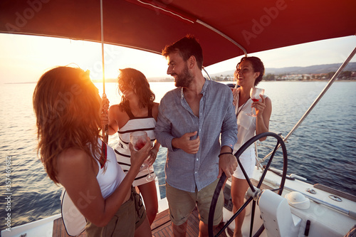 Friends  drinking on a yacht and enjoying at vacation and luxury travel at sunset.. © luckybusiness