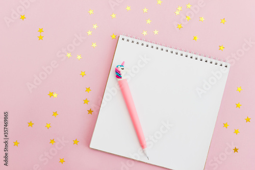 Sketchbook for girl and unicorn pen decorated golden confetti on pink background. Setting goals for the year. The concept of dreams and making wishes.