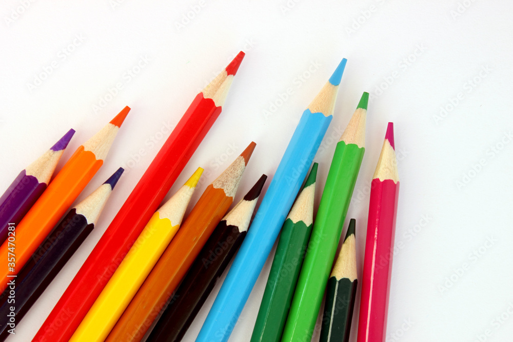 Colored pencils on a white background. Lots of different colored pencils. Colorful pencil. Pencils are sharp. Pencils lie diagonally in the lower left corner. Close-up. Copy space. Background. Flatlay Colored pencils on a white background. Lots of different colored pencils. Colorful pencil. Pencils are sharp. Pencils lie diagonally in the lower left corner. Close-up. Copy space. Background. Flatlay