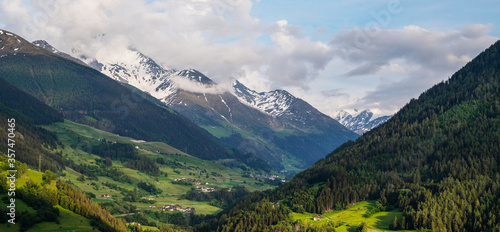 Scenic view of beautiful Swiss Alps mountains. Canton du Valais, Switzerland. Picturesque Alpine village in background. Swiss Alps with snow on top. Switzerland in summer. Alpine landscape © eskstock