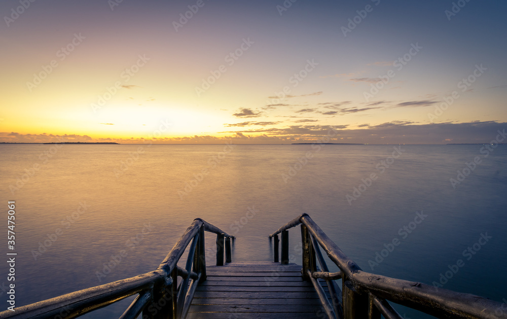 Stairs leading to ocean during sunrise with dreamy water