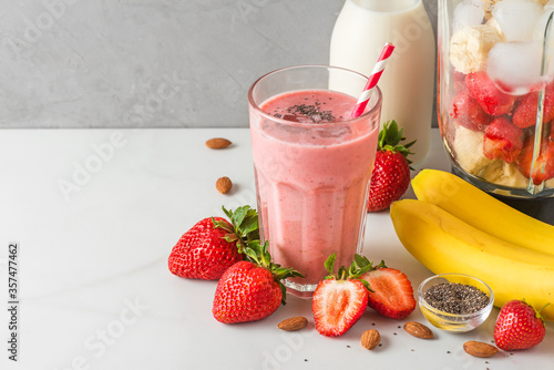 Murais de parede Glass of strawberry and banana vegan smoothie or milkshake made of almond milk w